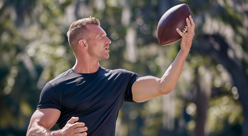Man catching a football wearing Nautilus Energy Tee